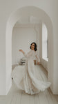 Bride twirling under a white arch, full skirt of an ivory glitter lace wedding dress fanning across a wooden floor, Galaxy Ivory