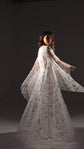 Model turning in a sheer star tulle robe that billows over a long ivory slip dress, dark studio, Infinity Slip Ivory