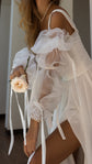 Close crop of ribbon ties trailing from a sheer organza sleeve, rose and pearl bracelet, chiffon wedding dress with slit, LUNA
