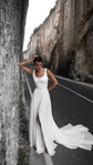 Sleeveless square-neck chiffon wedding dress with a side slit and long train, bride against a canyon wall on the road, LUNA
