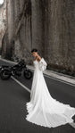 Bride walking along a canyon road, long chiffon train of a square-neck wedding dress trailing behind, motorbike parked, LUNA
