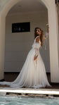 Bride in sunglasses posing in a white arch by a pool, chiffon wedding dress with puff organza sleeves and a sweeping train, LUNA
