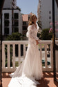 Smiling bride on a sunny balcony, A-line chiffon wedding dress with sheer organza sleeves and a train across the tiles, LUNA