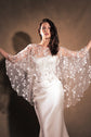 Model spreading her arms to show the round shape of a star tulle bridal cape over a corset gown, Lunar Eclipse Cape Ivory