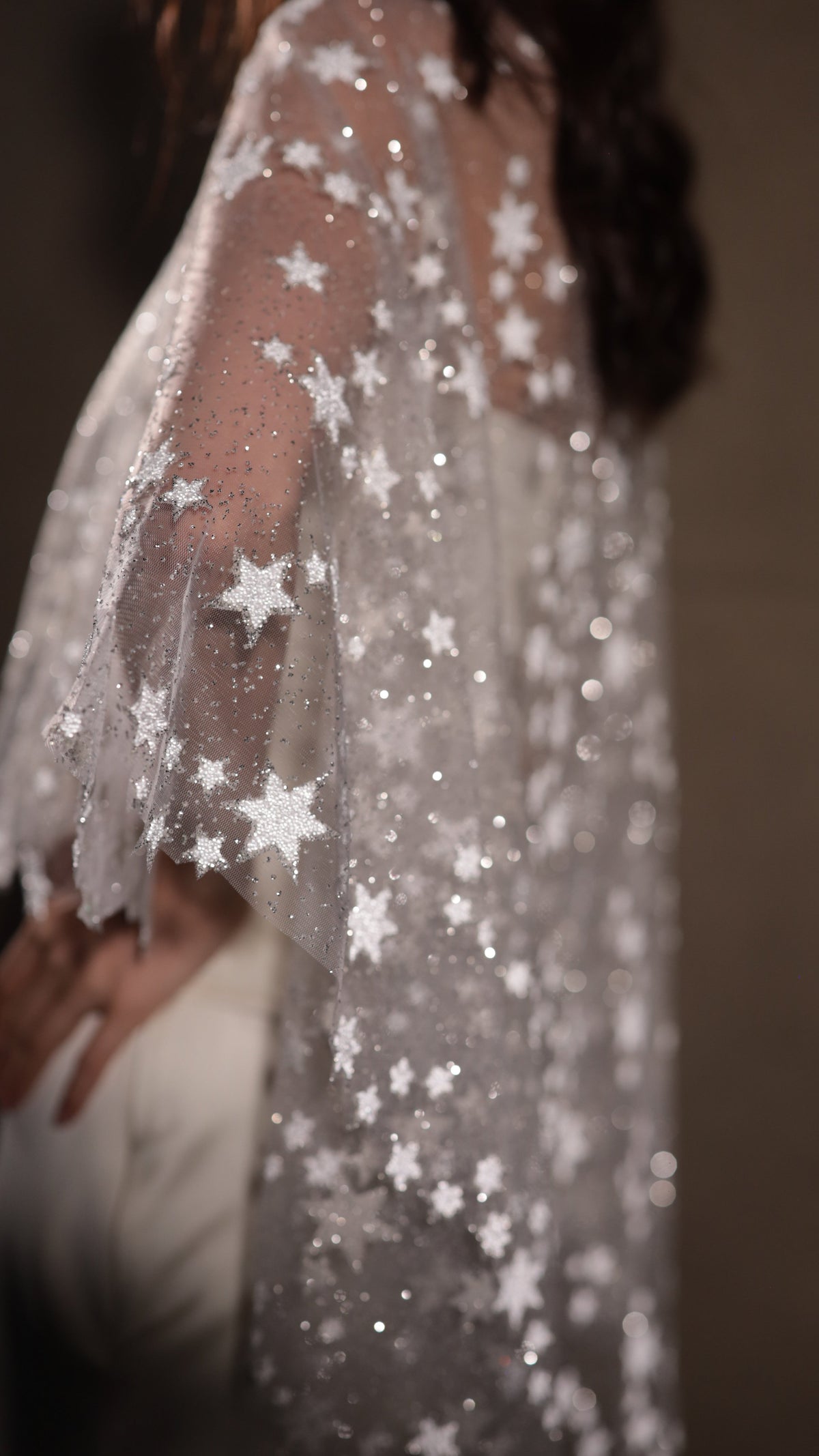Macro of stitched stars and sparkling dots on the sheer tulle edge of an ivory bridal cape, Lunar Eclipse Cape Ivory