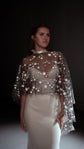 Black celestial bridal cape with white stars and a high neck over a satin gown and ribbon choker, dark studio. Lunar Eclipse Cape Black by Ephemeris