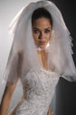 Close portrait framed by a structured two-tier wedding veil in light tulle, ribbon at the neck, Madonna Veil