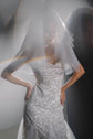 Soft-focus shot through a layered tulle wedding veil, light flare across a sparkling star gown, Madonna Veil
