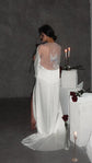Back view in low light of a satin bridal robe with a sheer back panel and butterfly embroidery, train on concrete, Metamorphosis Robe