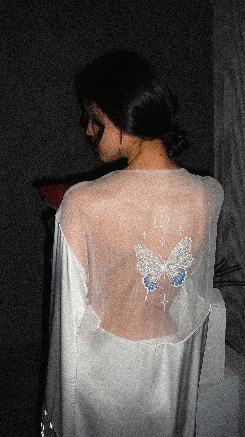 Close back crop of the sheer yoke on an ivory bridal robe with a blue-tipped butterfly, crescent moon and stars, Metamorphosis Robe