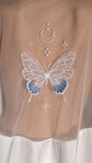 Macro of the embroidered butterfly in an ivory and blue gradient with moon and star motifs on sheer tulle, bridal robe, Metamorphosis Robe