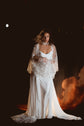 Bride in a satin bridal robe with sheer star sleeves over a cowl slip dress and lace choker, glowing cloud backdrop, Metamorphosis Robe