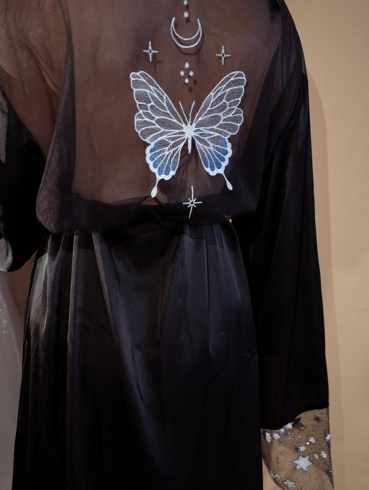 Close-up of a black bridal robe back, butterfly, moon and star embroidery on the sheer panel, Metamorphosis Robe Black