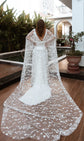 Cathedral-length bridal cape with stars pooled on a wooden deck, daylight back view by a pool and palms, Milky Way Cape Black