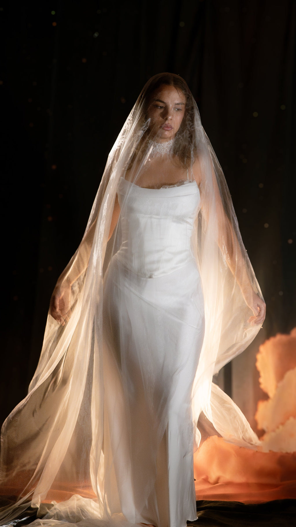 Bride walking under a sheer super organza mantilla veil worn over the face, glowing in warm light, Moonglade wedding veil