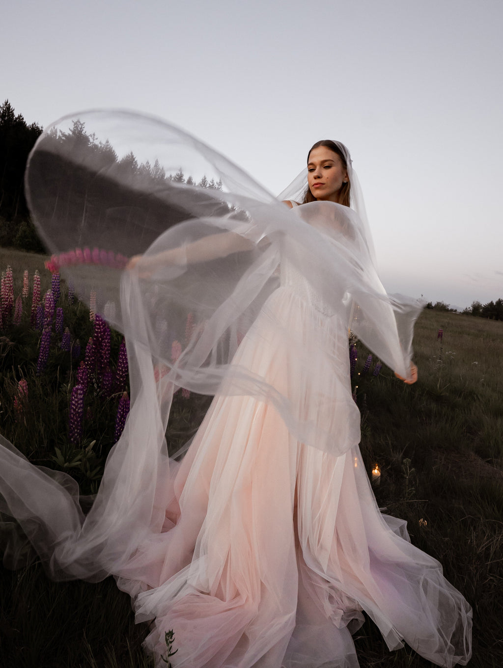 Long super organza wedding veil flying in a wide arc in a wildflower field at dusk, Moonglade