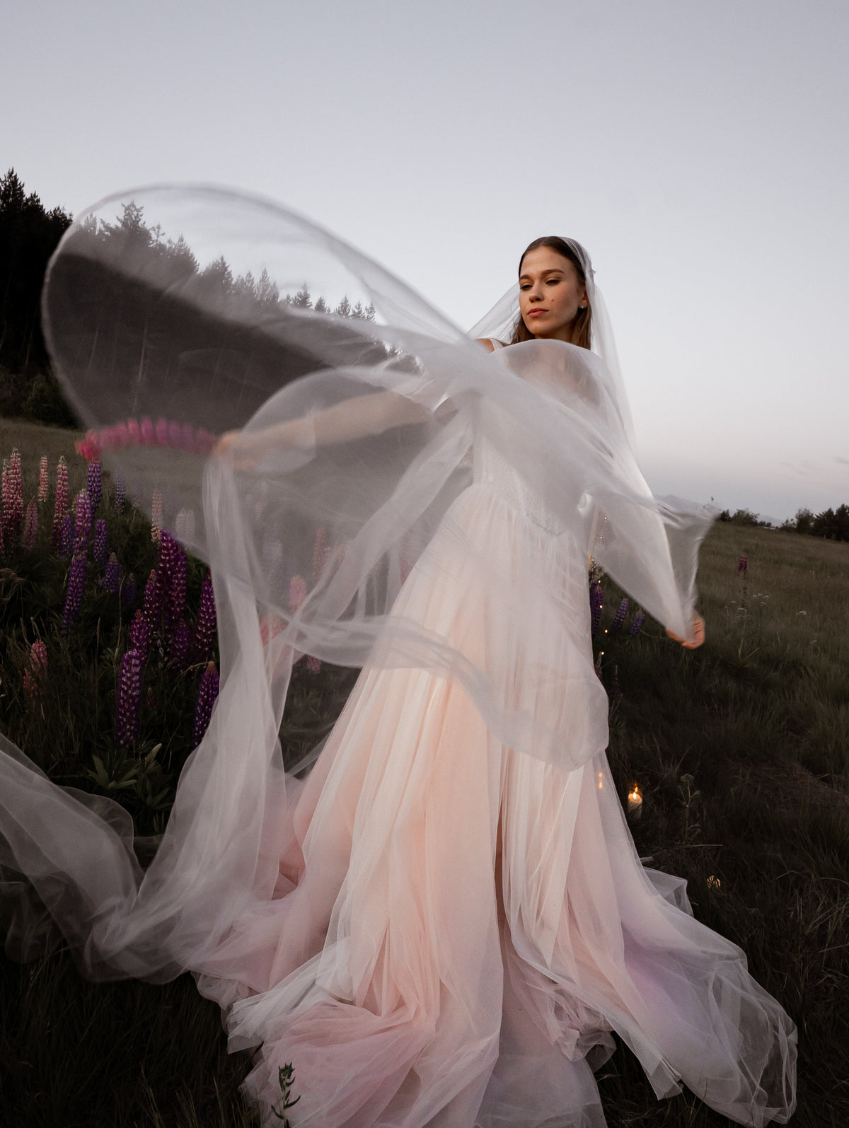 Long super organza wedding veil flying in a wide arc in a wildflower field at dusk, Moonglade