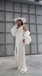 Full-length look with a petal bridal jacket slipping off the shoulders over a long V-neck slip dress, wide hat, warehouse, My Darling Hurricane