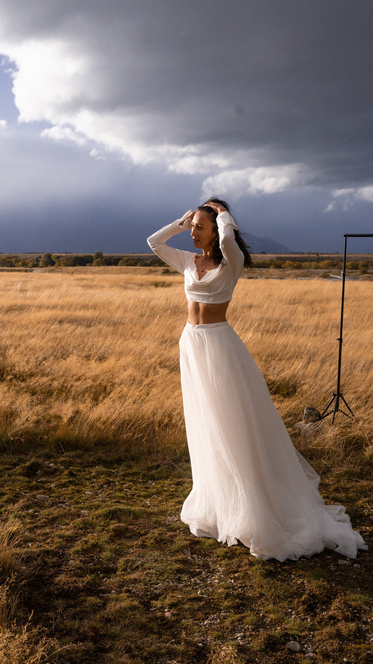 Natural-waist tulle bridal skirt flowing to the ground, bride touching her hair under a stormy sky, Olivia Skirt Sample