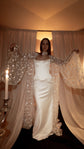 Bride in a satin corset gown with a sheer star bridal robe held open like wings, candles and drapes behind, Orion Robe
