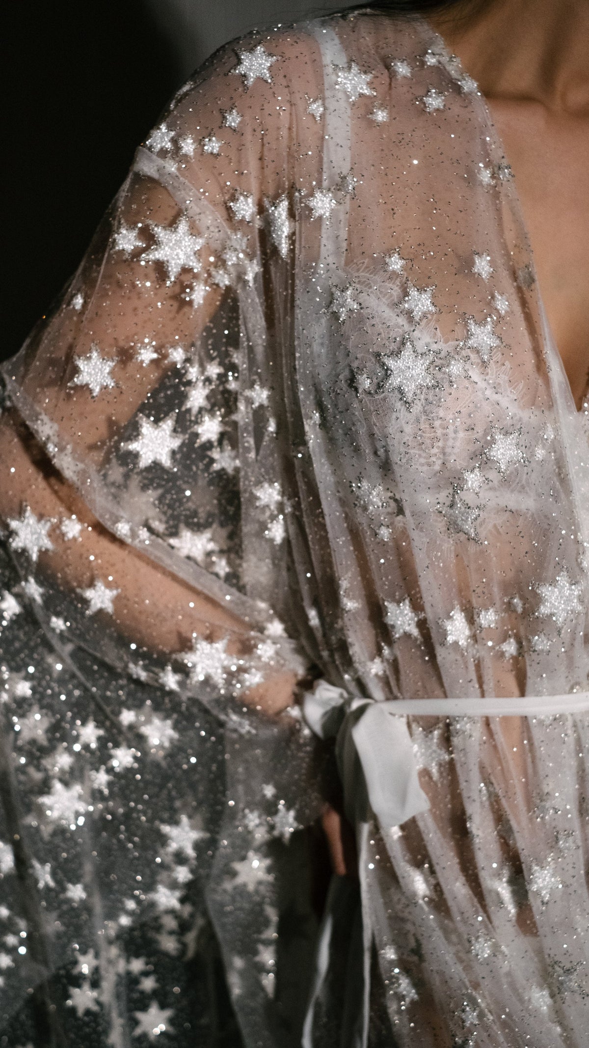 Close-up of glitter tulle and stars on a bridal robe sleeve with a satin ribbon tie, Orion Robe