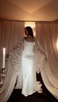 Sheer star bridal robe slipping off the shoulders over a satin corset gown, bride looking aside by candlelight, Orion Robe