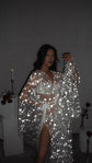 Model holding a phone up in a tied star bridal robe with bell sleeves, flash-lit stars, Orion Robe