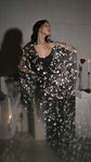 Model with eyes closed and hand at her chest in a black star bridal robe over a black slip, blurred foreground, Orion Robe Black