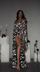 Model walking barefoot in a black star bridal robe, leg through the slit, roses and candles behind, Orion Robe Black