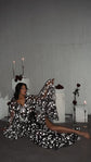 Model reclining on the floor in a black star bridal robe, one sleeve raised, candles and roses behind, Orion Robe Black