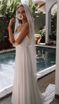 Pearl fingertip wedding veil framing a bride holding a rose to her face, full-length poolside view, Pearl Whispers Veil