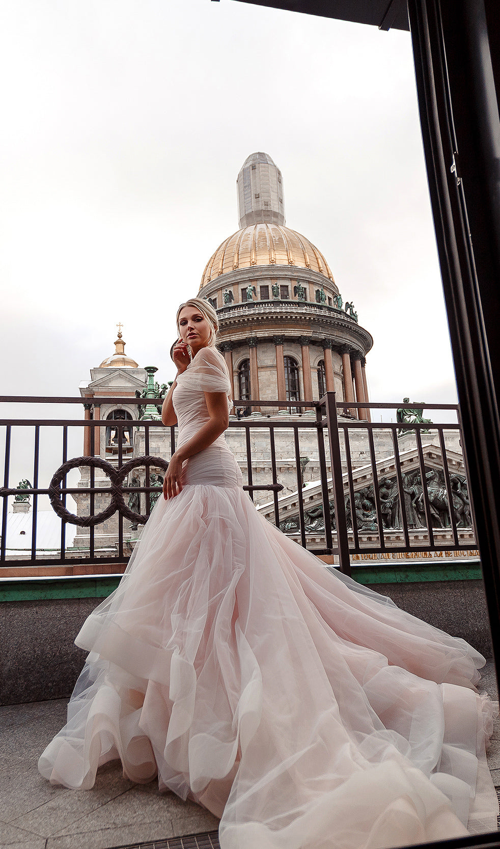 Bride on a rooftop terrace in a blush fit and flare wedding dress, domed cathedral behind, Peony