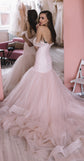 Bride by a mirror in a blush tulle wedding dress, off-shoulder back and full train in a pink fitting room, Peony