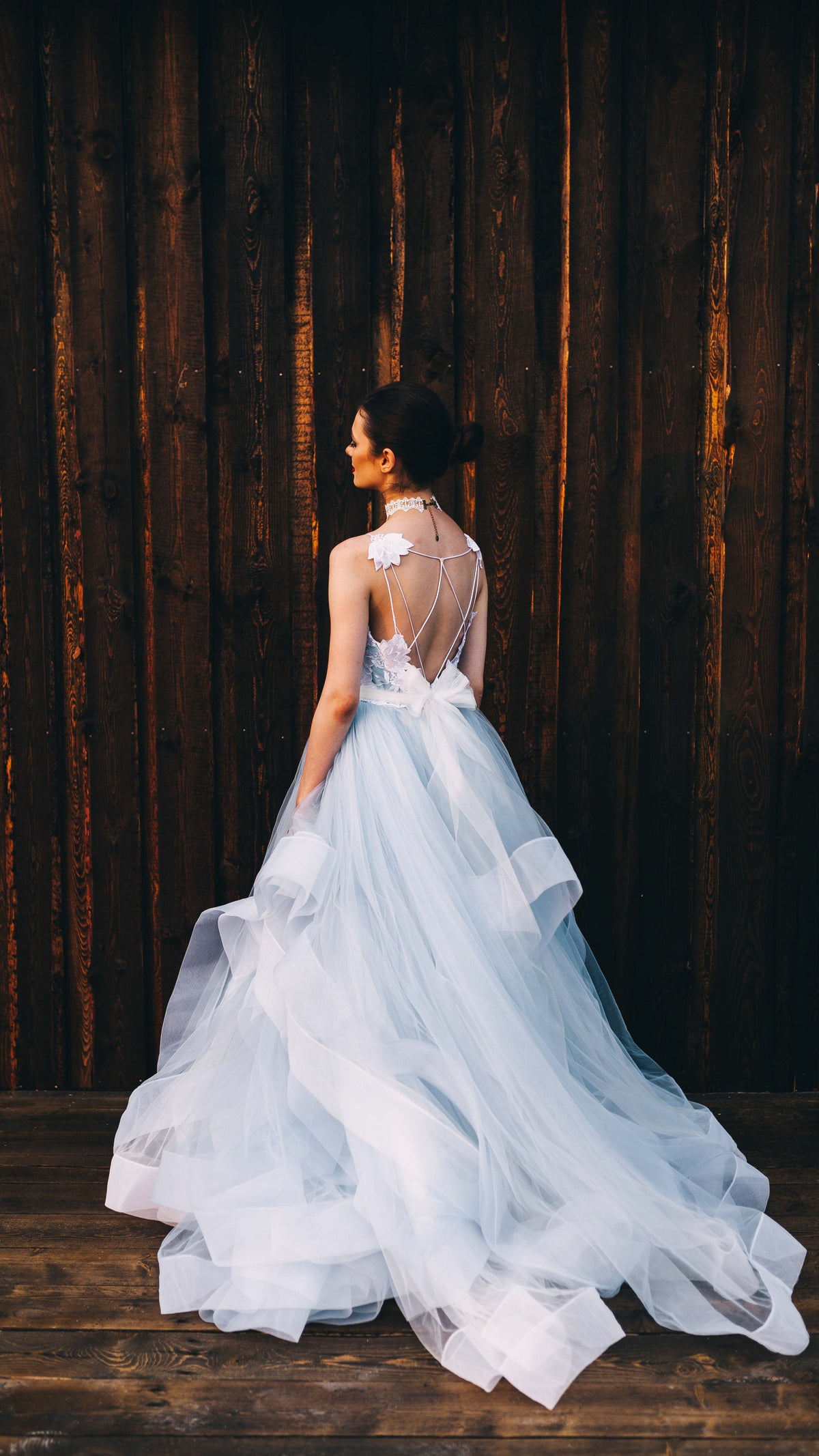 Blue tulle bridal skirt with layered horsehair trim and a long sweep, back view against a dark timber wall, Ready or Not Blue Sample by Ephemeris