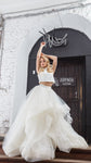 Ivory two-piece wedding dress, high-neck crop top and full tulle skirt with horsehair trim, bride by an arched door, Ready or Not Ivory by Ephemeris