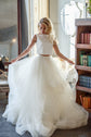 Bride holding out the tulle skirt of an ivory two-piece wedding dress, cut for dancing, sunny library room, Ready or Not Ivory