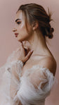 Side profile of a bride touching her neck, tulle puff sleeve of an off-shoulder wedding dress, pink backdrop, Savanna