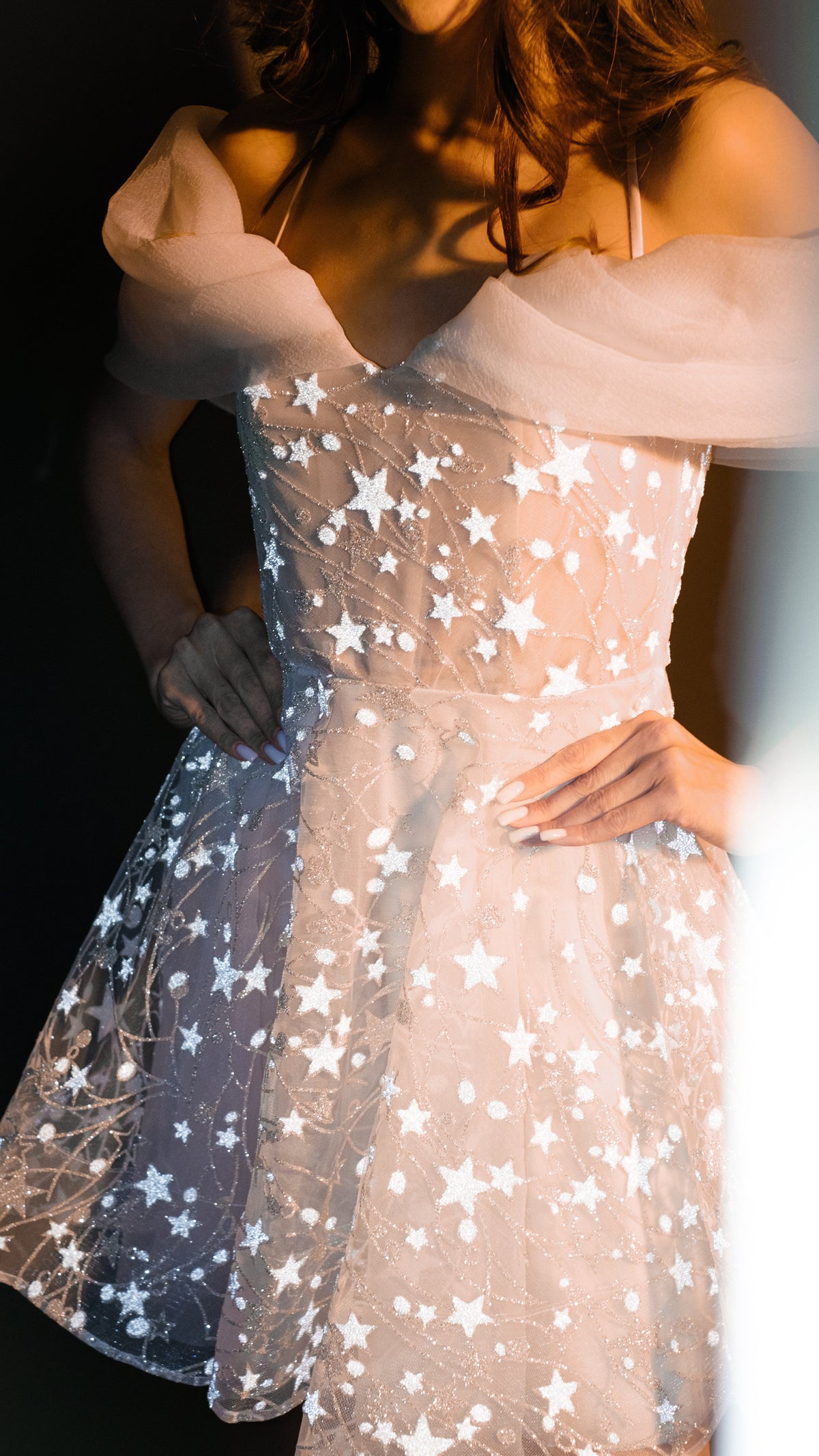 Torso crop of a star lace mini wedding dress, organza off-shoulder drapes and flared skirt in warm light, Shooting Star