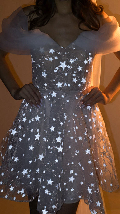 Close-up of a star lace mini wedding dress with hands on hips, structured bodice and soft off-shoulder drapes, Shooting Star
