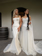 Two brides in a winery hall, one in a strapless satin bridal corset with a fitted skirt, the other in an ivory satin gown, Solana Corset