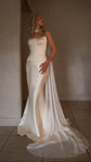 Bride gazing upward in a strapless bridal corset with a chiffon scarf flowing into the satin train, warm room, Solana Corset