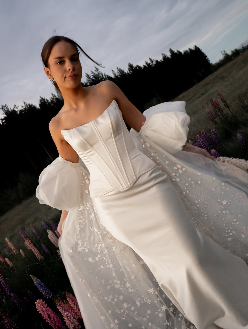 Satin corset and skirt bridal separates with a star tulle overskirt sweeping through lupins, elopement at dusk, Solana Ensemble