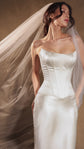 Satin bridal skirt and strapless corset under a sheer veil lifted by the wind, warm brown studio backdrop, Solana Skirt