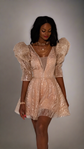 Champagne mini wedding dress with a plunging V neck, ruffled puff sleeves and a flared sparkling skirt, model in studio, Soleil