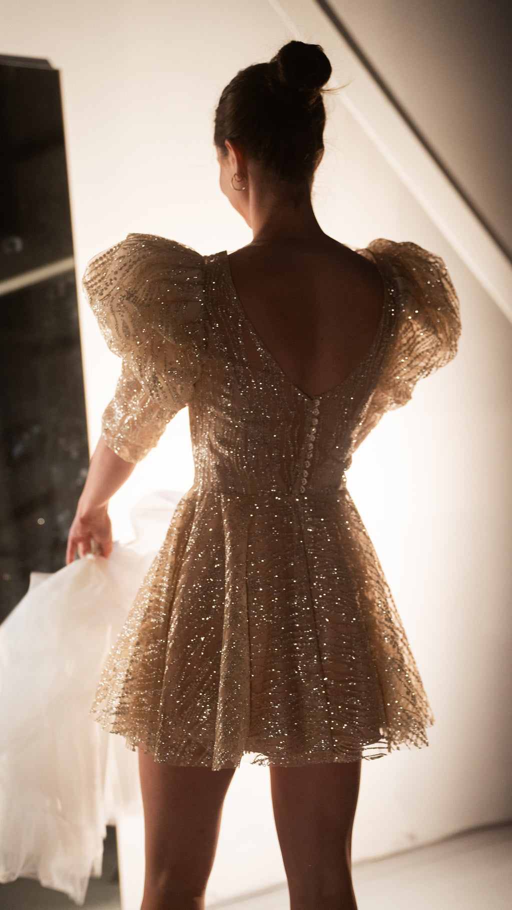 Back view of a champagne mini wedding dress showing the scoop back, button closure and puff sleeves, ceremony to reception, Soleil
