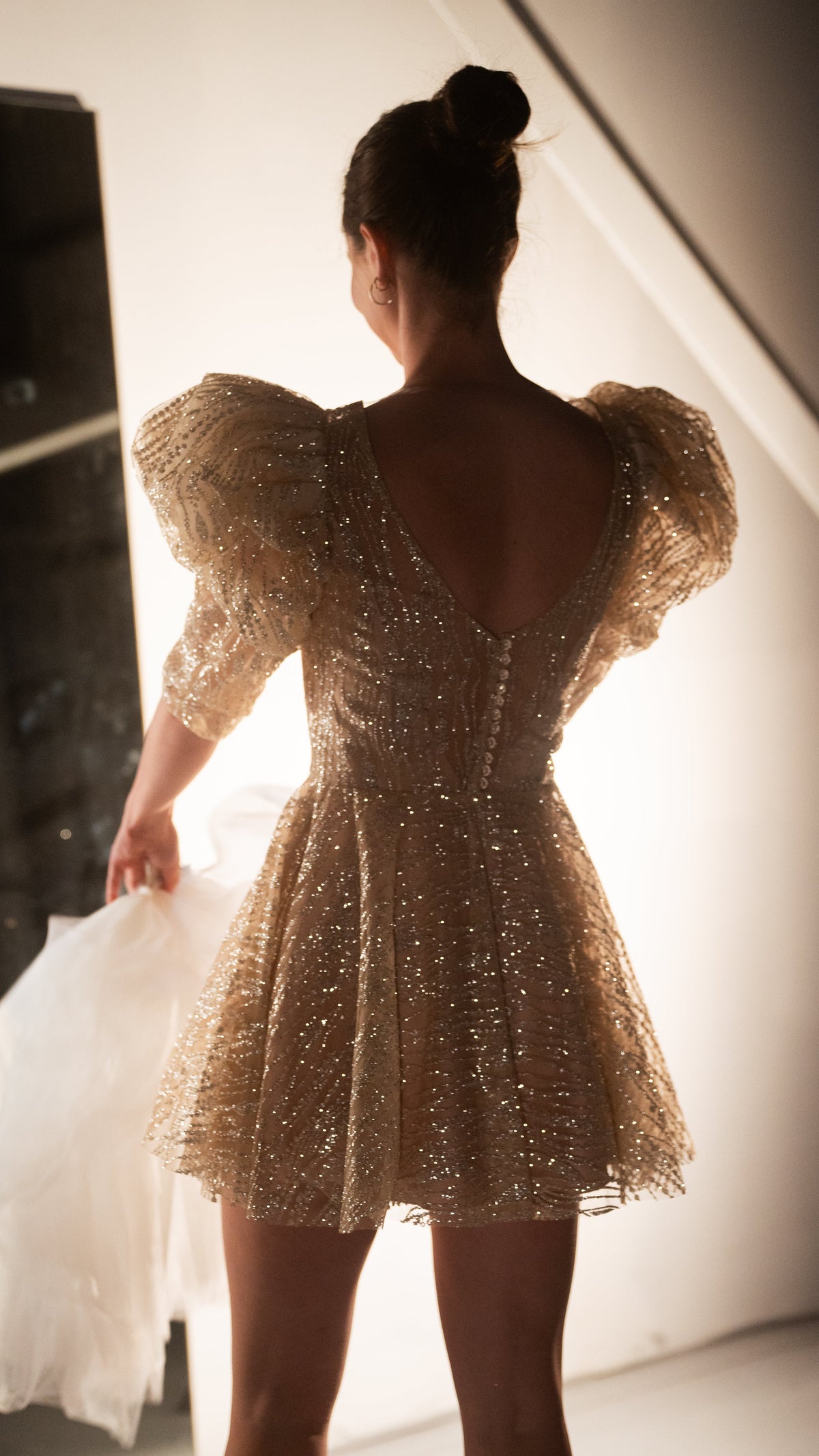 Back view of a champagne mini wedding dress showing the scoop back, button closure and puff sleeves, ceremony to reception, Soleil