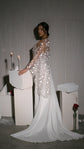 Bride in profile resting a hand on a candlelit plinth, star lace bridal robe falling into a long chiffon train, Stargazer Robe Ivory