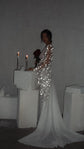 Side view of a chiffon bridal robe with a long sweeping train and star lace sleeve, bride at a candle plinth with roses, Stargazer Robe Ivory