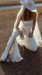 Bride kneeling on a roadside in star lace flared bridal trousers, cowboy hat, tulle veil and sheer star gloves, Sun Flares
