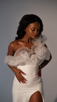 Waist-up view of a crepe sample wedding dress, ruffled tulle neckline and thigh slit, hands at the waist, Terra Sample